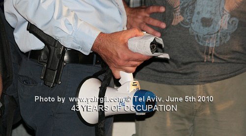 רימון העשן, לאחר שהתקרר, בידי קצין משטרה. הפגנת שלום עכשיו - 5.6.2010 מול מוזיאון תל אביב