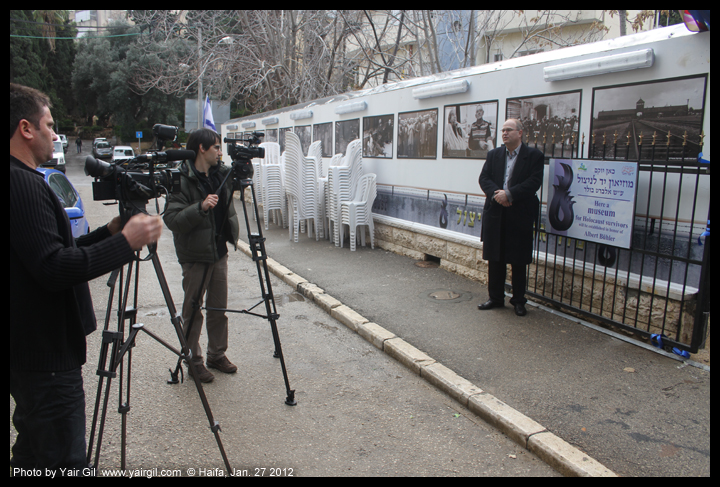 - Dr. Juergen Buehler -  Executive Director of the International Christian Embassy, Jerusalem. Picture from Haifa Jan 27 2012.  Stop supporting Holocaust industry.  Support holocaust survivors.   נציג השגרירות הנוצרית בישראל - מתראיין על רקע תפאורה דמוית קרונות רכבת