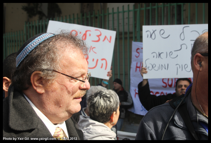 שר המדע והטכנולוגיה ויו"ר מפלגת הבית היהודי הפרופ' דניאל הרשקוביץ בפתיחת "מוזיאון יד לניצול" 27.1.2012, יום השואה הבינלאומי, חיפה. המפגינים מחו על הפניית משאבים לעניינים שאינם קשורים ברווחת הניצולים והטיפול בהם.