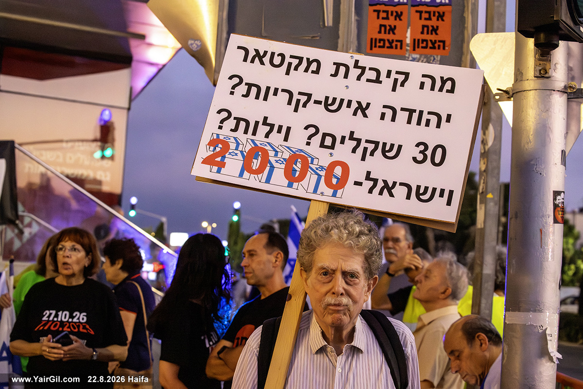 על השלט כתוב: מה קיבלת מקטאר יהודה איש קריות / 30 שקלים? וילות? וישראל 2000 (ארונות)